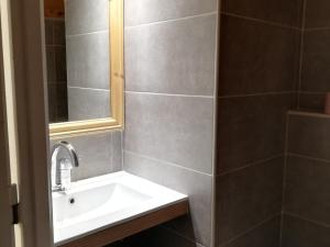 uma casa de banho com um lavatório e um espelho em Appartement Les Menuires, 2 pièces, 7 personnes - FR-1-452-30 em Les Menuires