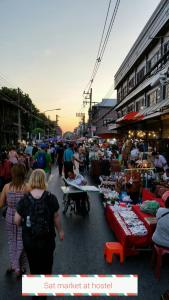 a group of people walking through an outdoor market at Chiang Mai Happy House Hostel in Chiang Mai