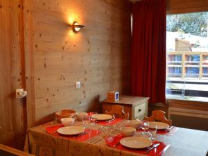 una mesa con platos y copas de vino. en Studio Les Menuires, 1 pièce, 4 personnes - FR-1-452-22, en Les Menuires