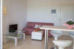 uma sala de estar com um sofá rosa e uma mesa em IRIS HOME 4 em Paralia Katerinis
