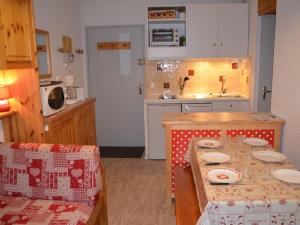 a kitchen with a table with plates on it at Appartement Les Menuires, 1 pièce, 4 personnes - FR-1-452-31 in Les Menuires