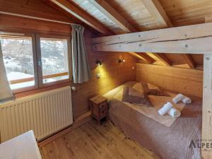 een kamer met een bed in een blokhut bij Chalet haut de gamme 8 chambres avec sauna à 250m des pistes, St Martin de Belleville - FR-1-452-75 in Saint-Martin-de-Belleville