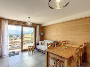 ein Esszimmer mit Tisch und Couch in der Unterkunft Appartement de standing pour 6 pers. à La Toussuire avec parking - FR-1-416-173 in La Toussuire