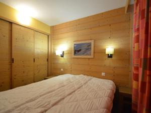 a bedroom with a bed in a room with wooden walls at Appartement Les Menuires, 2 pièces, 4 personnes - FR-1-452-89 in Les Menuires