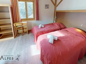 two beds in a room with red sheets at Appartement Saint-Martin-de-Belleville, 6 pièces, 12 personnes - FR-1-452-69 in Saint-Martin-de-Belleville