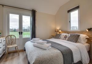 a bedroom with a large bed with towels on it at The Bolthole and Warren in Biddenden
