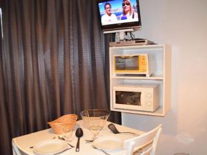 uma mesa de jantar com um micro-ondas e uma televisão em Studio Les Menuires, 1 pièce, 2 personnes - FR-1-452-87 em Les Menuires