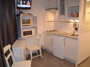 uma pequena cozinha com um lavatório e um micro-ondas em Studio Les Menuires, 1 pièce, 2 personnes - FR-1-452-87 em Les Menuires