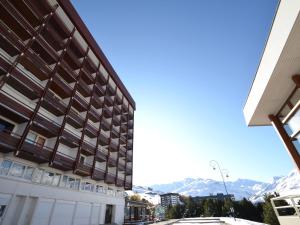 vistas a un edificio con montañas en el fondo en Appartement Les Menuires, 2 pièces, 6 personnes - FR-1-452-123, en Les Menuires