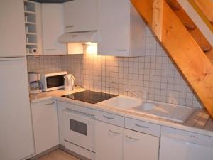 kuchnia z białymi szafkami i zlewem w obiekcie Appartement Les Menuires, 2 pièces, 6 personnes - FR-1-452-119 w Les Menuires