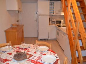 a kitchen with a table with plates and glasses on it at Appartement Les Menuires, 2 pièces, 6 personnes - FR-1-452-119 in Les Menuires