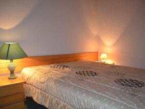 sypialnia z łóżkiem i lampką na komodzie w obiekcie Appartement Les Menuires, 2 pièces, 6 personnes - FR-1-452-119 w Les Menuires