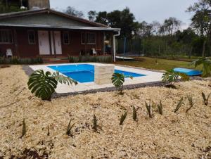 a yard with a swimming pool in front of a house at Don Alejandro Apart Iguazu in Puerto Iguazú