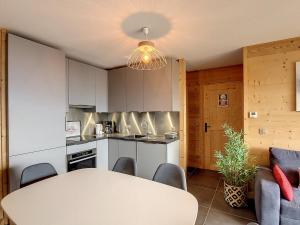 a kitchen and dining room with a table and chairs at Appartement neuf pour 6 pers. avec parking, balcon et sur pistes - FR-1-416-186 in La Toussuire