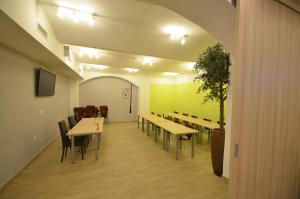 un comedor con mesas, sillas y una planta en Hotel Emonec en Liubliana