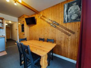 a dining room with a wooden table and baseball bats on the wall at Appartement Les Menuires, 2 pièces, 5 personnes - FR-1-452-131 in Les Menuires