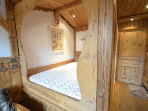 レ・メニュアールにあるStudio Les Menuires, 1 pièce, 4 personnes - FR-1-452-101の木製の部屋にベッド1台が備わるベッドルーム1室があります。