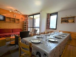 uma sala de jantar com uma mesa com pratos e copos de vinho em Appartement Les Menuires, 3 pièces, 10 personnes - FR-1-452-239 em Les Menuires