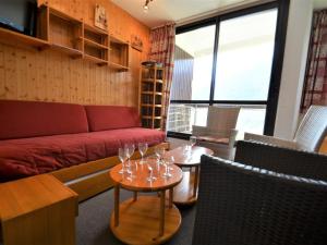 uma sala de estar com um sofá e duas mesas com copos de vinho em Appartement Les Menuires, 3 pièces, 10 personnes - FR-1-452-239 em Les Menuires
