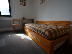 um quarto com uma cama, uma cadeira e uma janela em Appartement Les Menuires, 3 pièces, 10 personnes - FR-1-452-239 em Les Menuires