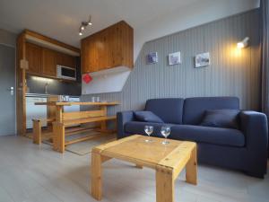 a living room with a blue couch and a table at Studio Les Menuires, 1 pièce, 4 personnes - FR-1-452-262 in Les Menuires