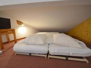 a bed with white pillows in a room at Appartement Les Menuires, 4 pièces, 8 personnes - FR-1-452-201 in Les Menuires