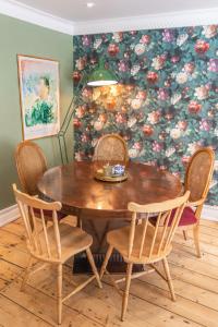 a dining room table and chairs with a floral wallpaper at House Arundel in Arundel