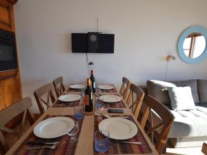 a dining room table with plates and wine bottles on it at Appartement Les Menuires, 2 pièces, 4 personnes - FR-1-452-256 in Les Menuires