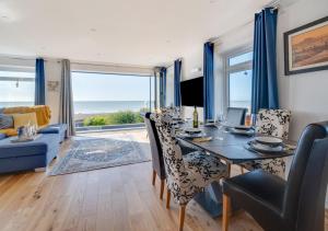 a dining room with a table with chairs and a view of the ocean at Vitamin Sea House in Worthing