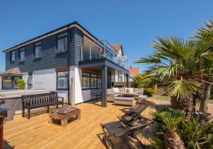 a house with a deck with chairs and a patio at Vitamin Sea House in Worthing