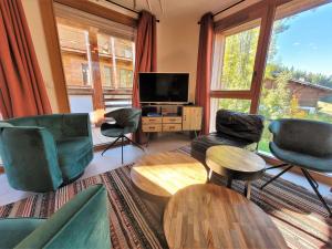 ein Wohnzimmer mit Stühlen und einem Flachbildfernseher in der Unterkunft Appartement lumineux 4 pièces aux Gets, accès direct aux pistes, 6 pers, garage, Wi-Fi - FR-1-598-37 in Les Gets