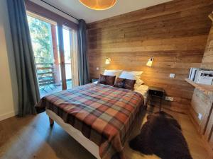 ein Schlafzimmer mit einem Bett und einem Hund, der auf dem Boden liegt in der Unterkunft Appartement lumineux 4 pièces aux Gets, accès direct aux pistes, 6 pers, garage, Wi-Fi - FR-1-598-37 in Les Gets