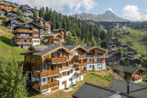 a group of houses on a hill with trees at Camelot 5 in Bettmeralp