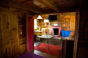 a living room with a table and a fireplace at Cabañas los Venados in Mazamitla