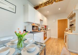 a kitchen with a glass table with dishes on it at Little Bourne in Tonbridge