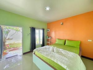1 dormitorio con paredes de color naranja y verde y 1 cama en Ava Beach Pakbara en Ban Pak Ba Ra