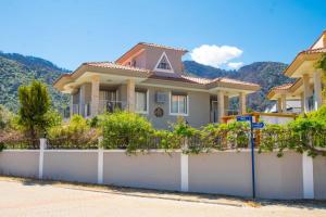 a house with a white fence at Villa Cozy in Marmaris