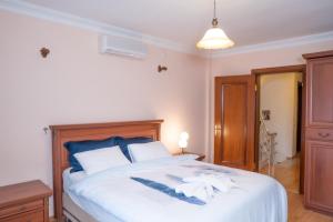 a bedroom with a large white bed with two feathers on it at Villa Cozy in Marmaris +33 photos