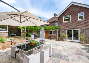 a patio with a table and an umbrella at Little Ponds in Cross in Hand