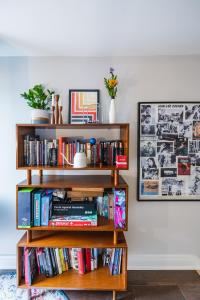 a book shelf filled with books next to a wall at Bedroom in thoughtfully decorated East Passyunk home (South Philadelphia) in Philadelphia