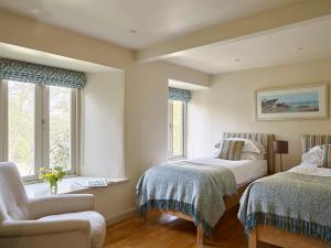 Yennadon Cottage في توتنس: غرفة نوم بسريرين وكرسي ونوافذ +24 صورة