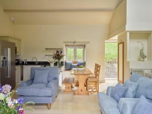 ein Wohnzimmer mit blauen Sofas und einem Tisch in der Unterkunft Haytor Cottage in Totnes