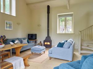 ein Wohnzimmer mit einem blauen Sofa und einem Kamin in der Unterkunft Maristow Cottage in Totnes