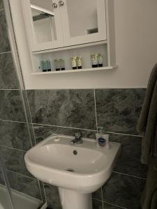 W łazience znajduje się biała umywalka i lustro. w obiekcie Connah's Quay Park Farm Barns w mieście Connahs Quay