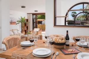 a table with glasses of wine and a basket of bread at KARAT Villa Atlantida in Playa de las Americas