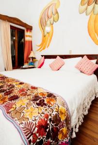 una camera con 2 letti e un copriletto floreale di Mansion de los Angeles a San Cristóbal de Las Casas