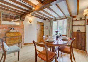 a dining room with a wooden table and chairs at Camberley Cottage in Happisburgh