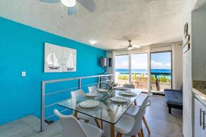 Cancun Ocean view في كانكون: غرفة طعام مع طاولة وكراسي والمحيط