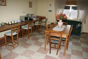 ein Esszimmer mit einem Tisch, Stühlen und einer Mikrowelle in der Unterkunft Salento Al Mare in Taviano