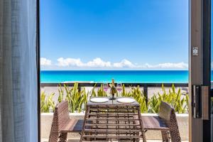 Cancun Ocean view في كانكون: طاولة مع كراسي وإطلالة على الشاطئ